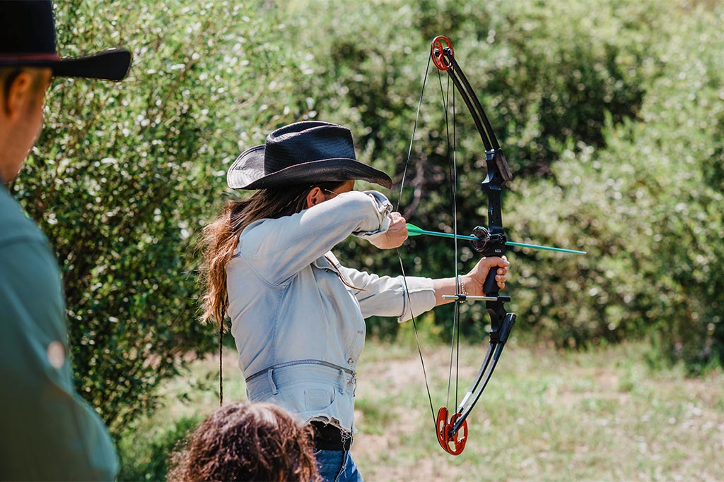 A C Lazy U Ranch guest shoots a bow at a target